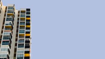 Tall residential apartments with geometric, colorful balconies under clear blue sky, copy space for text. Urban architecture image for real estate, housing, or city development context. photo