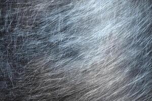 Cool-toned scratched metal surface with swirling fine lines. photo