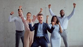 Five individuals showcase confidence and professionalism in a contemporary office setting. Their attire reflects a blend of formal and business casual styles, emphasizing teamwork and success. video