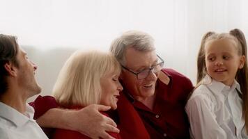 Family gathers in a bright living room, sharing laughs and stories during Thanksgiving Day celebration. The atmosphere is filled with warmth and joyful interaction among loved ones. video