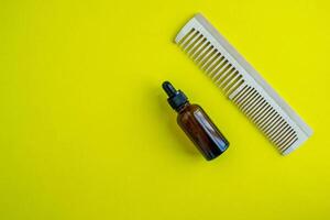 Cosmetic bottle and comb. Beauty salon, personal care products. Background with copy space. photo