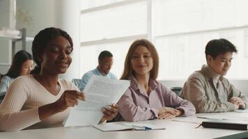 A group of diverse students collaborates on assignments in a bright study space. Each student contributes unique perspectives while discussing various topics, fostering teamwork and learning. video