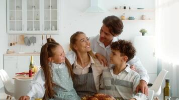 A joyful family celebrates Thanksgiving Day at home. They share laughter and warm moments while gathering around the dinner table, appreciating each other's company and the feast. video