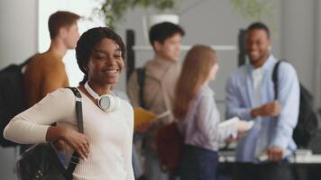African American lady standing over diverse group of college students is engaged in discussions and studying together in a vibrant university setting video