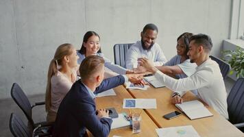 Group of diverse professionals gathered around a conference table in a modern office, discussing strategies and analyzing reports. Focus on teamwork and collaboration in a business setting. video