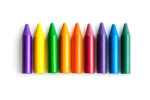 Ten vibrant crayons arranged in a straight line, showcasing a spectrum of colors against a plain backdrop that enhances their brightness photo