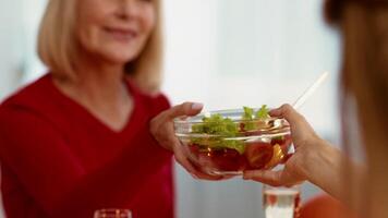 Family gathers around a table during Thanksgiving Day, enjoying a festive meal. A bowl with colorful salad is presented, highlighting the warmth of the celebration. video