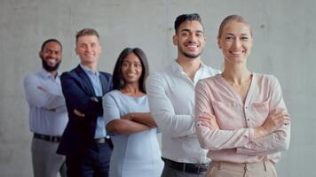 Five diverse business professionals stand confidently in a contemporary office setting. They display a sense of unity and ambition, preparing for a successful collaboration. video