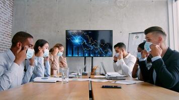 A diverse group of professionals engages in a strategy meeting in a contemporary office. They analyze data trends displayed on a digital screen, discussing results and planning next steps. video