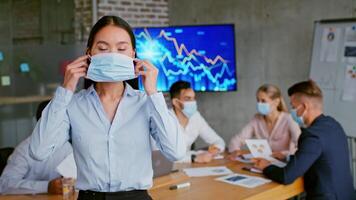 A professional Chinese woman stands confidently in a contemporary office while colleagues collaborate at a table behind her. Charts and graphs illustrate the focus on business growth. video