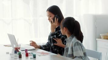 In a bright kitchen, a mother talks on the phone while her daughter curiously observes, child needs for attention video