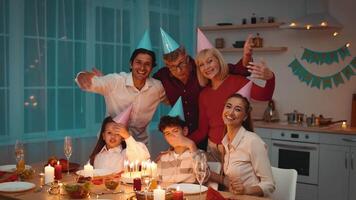 Family members gather around a festive table to celebrate Birthday, wearing party hats and sharing smiles. The atmosphere is filled with laughter, good food, and joyous moments. video