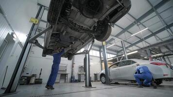 Mechanic working under raised car video