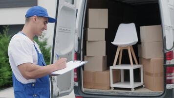 Worker Standing Beside Van Confirming Package Details video