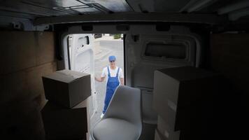 Worker Unloading Furniture Boxes from Delivery Van video