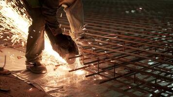 Industrial professional worker is cutting metal rebar with a circular saw. Construction of a factory, hangar 6 video