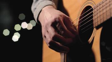 A musician is playing guitar on a large stage with audience members holding flashlights in the background. The auditorium is filled with beautiful flashing lights. 47 video