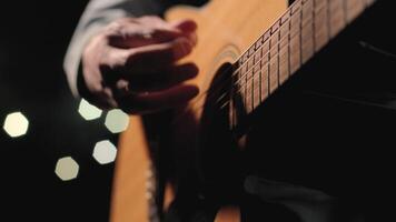 A musician is playing guitar on a large stage with audience members holding flashlights in the background. The auditorium is filled with beautiful flashing lights. 46 video