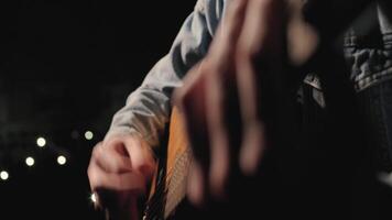 A musician is playing guitar on a large stage with audience members holding flashlights in the background. The auditorium is filled with beautiful flashing lights. 30 video