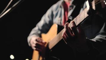 A musician is playing guitar on a large stage with audience members holding flashlights in the background. The auditorium is filled with beautiful flashing lights. 42 video