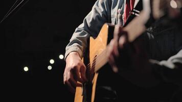 A musician is playing guitar on a large stage with audience members holding flashlights in the background. The auditorium is filled with beautiful flashing lights. 41 video
