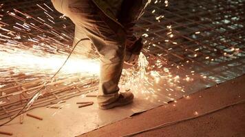 Industrial professional worker is cutting metal rebar with a circular saw. Construction of a factory, hangar 13 video