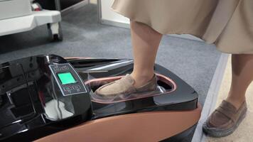 Automatic shoe cover dispenser for hygiene use. Close-up of a person using an automatic shoe cover dispenser, placing their foot inside to apply protective video