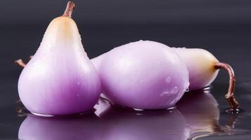 Three purple onions with water droplets, close-up view. photo