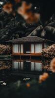 A small house sitting on the edge of a pond photo