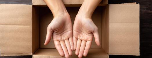 Two hands are holding out a box on a wooden table photo
