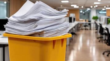 A yellow trash can full of papers photo