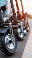 A row of three electric scooters parked on the street photo