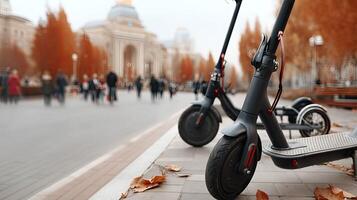 Two electric scooters are parked on the sidewalk photo