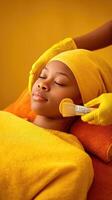 A woman getting a facial treatment with a yellow towel photo