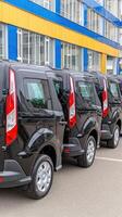 A row of black vans parked in a parking lot photo