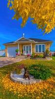A beautiful home with yellow leaves on the lawn photo