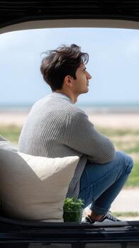 A man sitting in the back seat of a car looking out the window photo