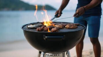 A man grilling meat on a grill on the beach photo