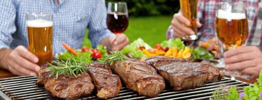 Two men are toasting steaks on a grill photo