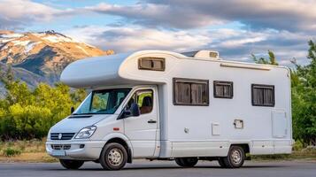 A white camper van parked in front of a mountain photo