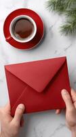Man holding red envelope with coffee cup on white marble table photo