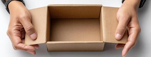 A person holding a cardboard box over a white surface photo