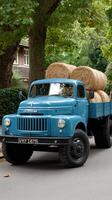 A blue truck with hay on it photo