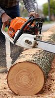 A man using a chainsaw to cut a log photo