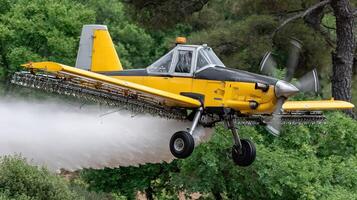 A yellow and black airplane spraying water on a field photo