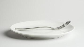 Fork resting on empty white plate on white background photo
