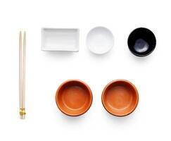 Pieces of traditional japanese tablewear. Small bowls and bamboo chopsticks isolated at white background. Top view, flat lay, copy space, white background photo