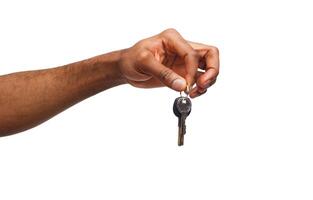 Black male hand holding key to house, car or business, motivation poster isolated on white background, copy space photo