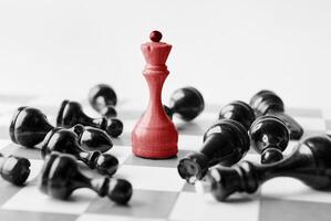 White chess queen beats blacks on chessboard over white background. Win and success concept, copy space photo
