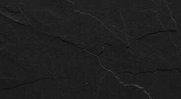 A black slate surface with cracks and cracks photo